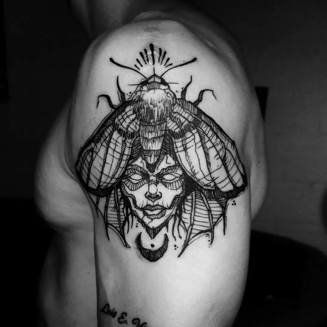 Polilla con un rostro en el centro, hecha en blackwork de línea
