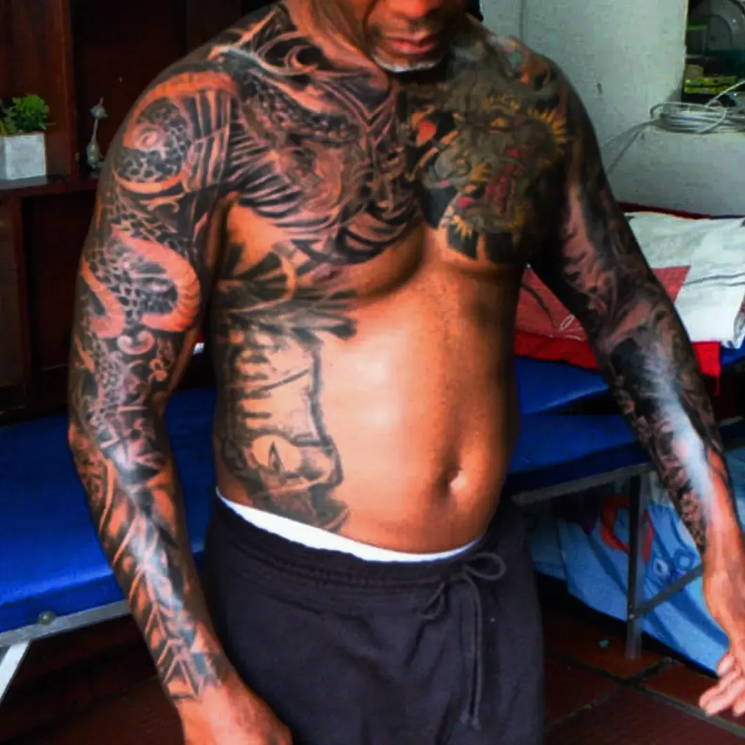 Torso y los dos brazos cubiertos en estilo japonés, con dragones y agua en negro y gris