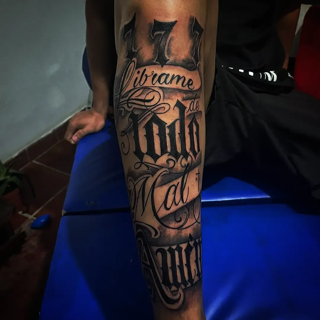 Lettering en el antebrazo con números y letra gótica ornamentada
