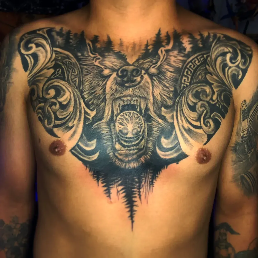 Pieza de pecho completo en negro, con ornamento y una figura animal en el centro