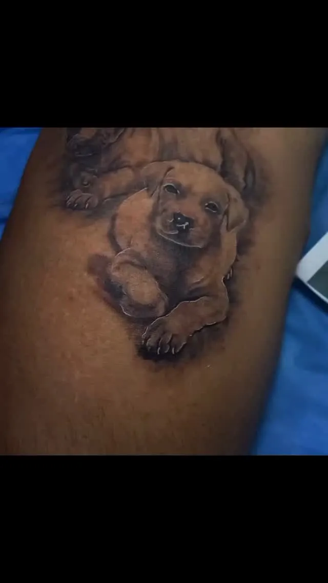 Dos cachorros tatuados con realismo en negro y gris